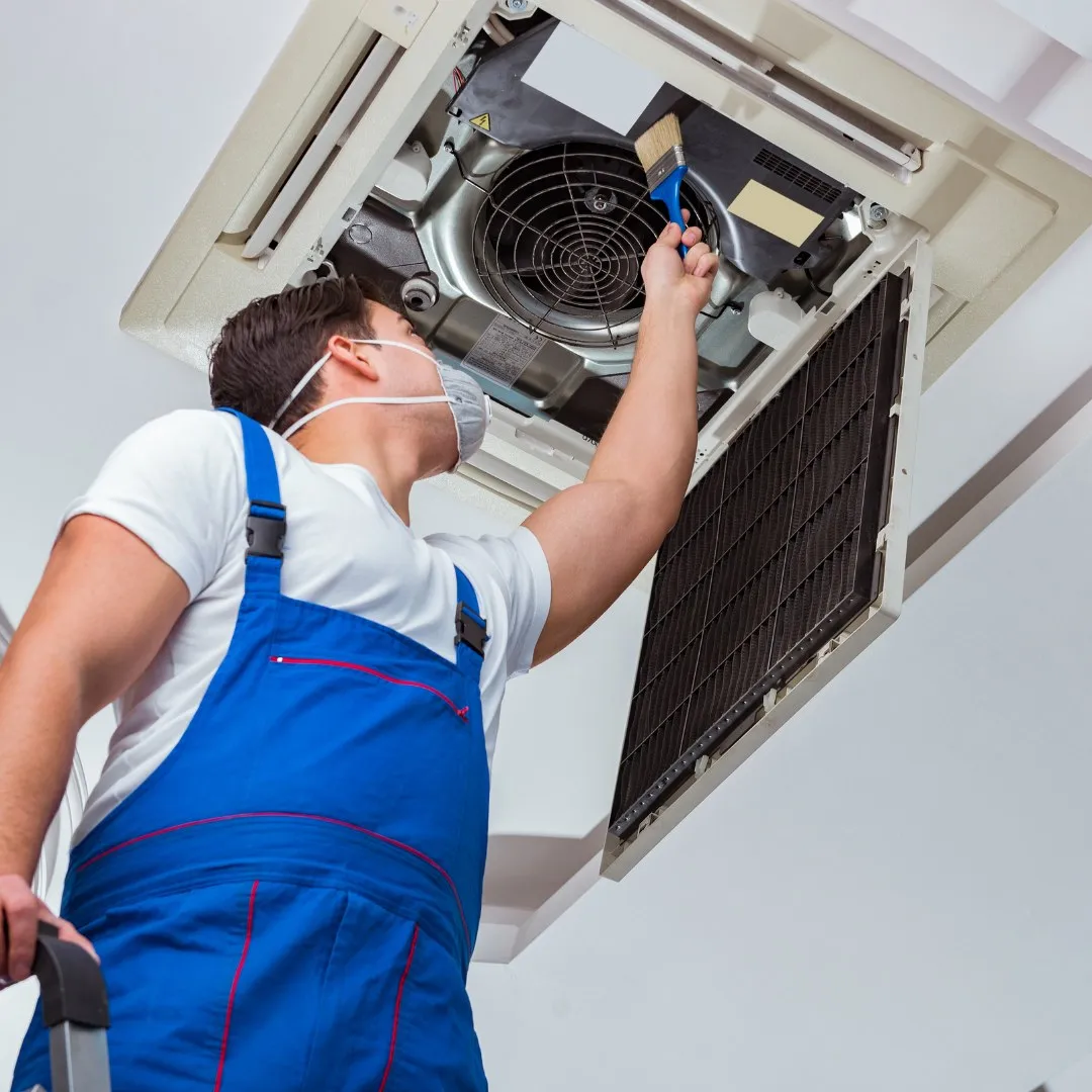 Technician working on a ceiling-mounted air conditioner