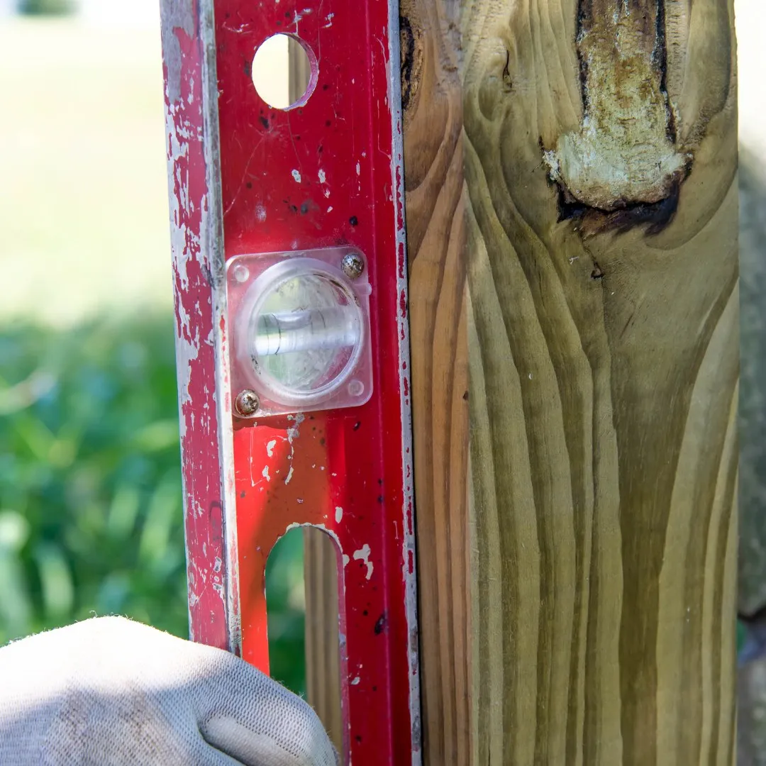 Checking a wood fence post with a level