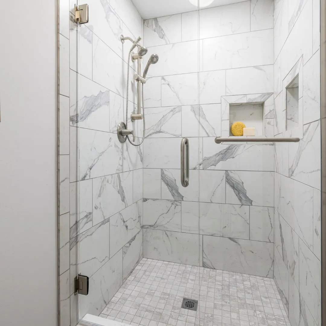 Frameless glass shower door with marble-look tile