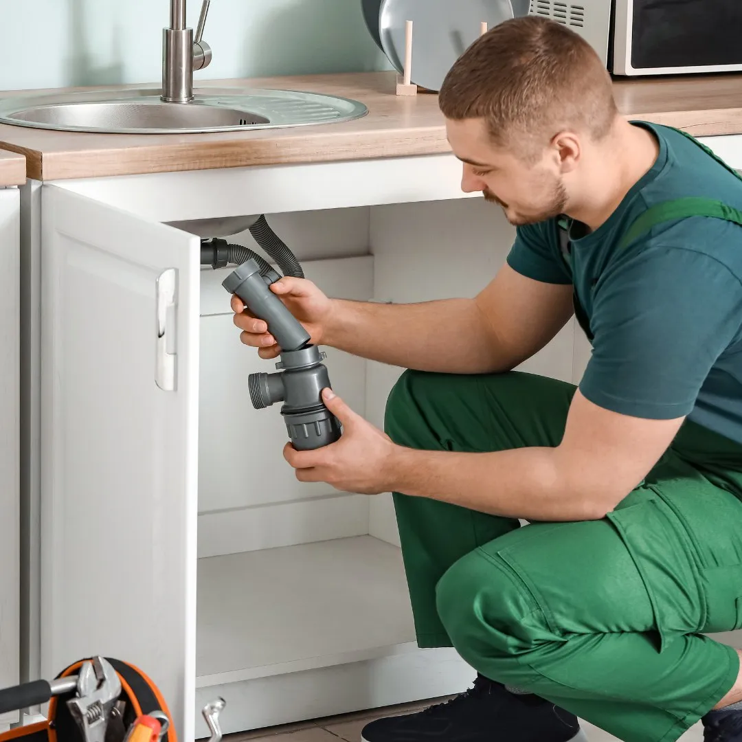Handyman working on a sink drain pipe