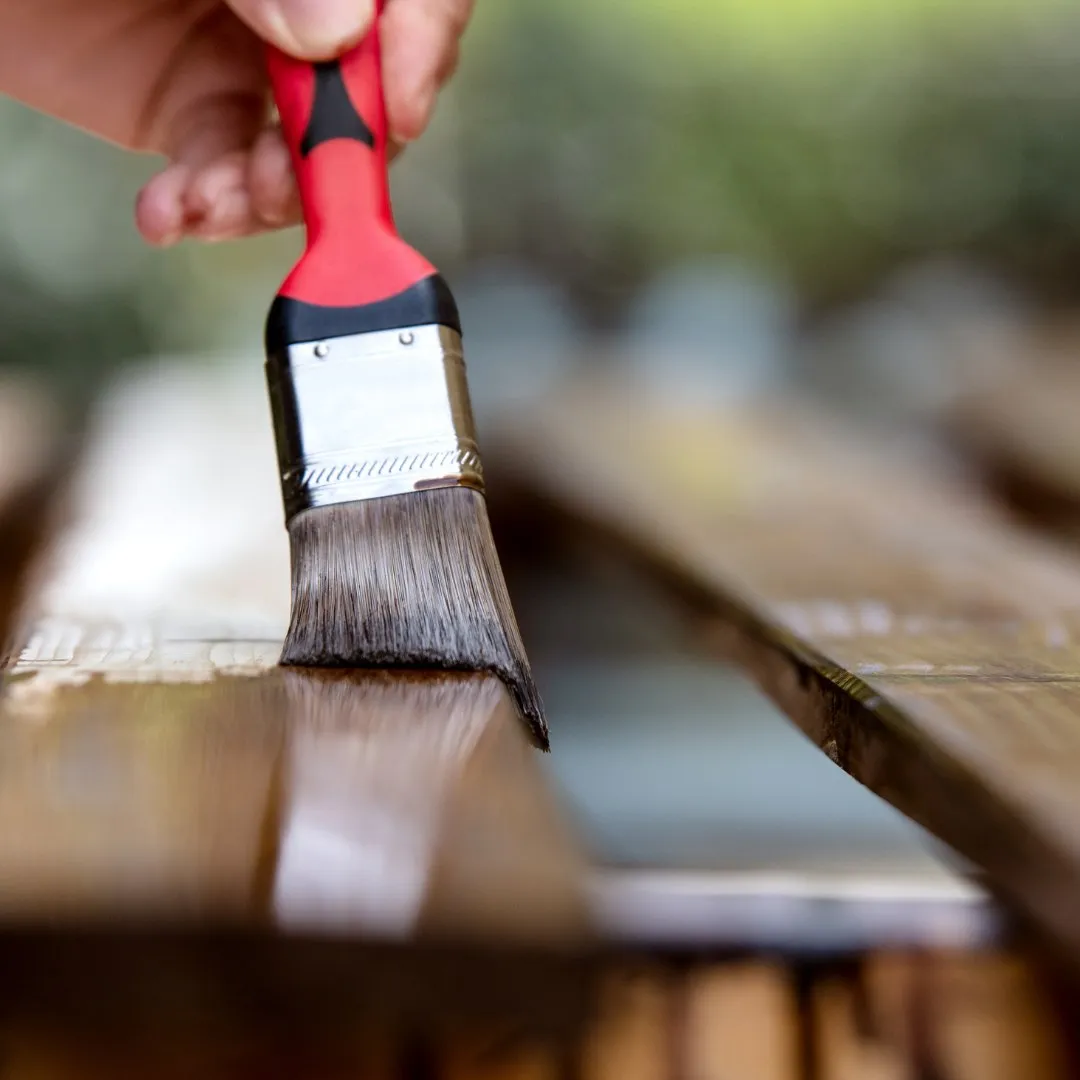Brushing stain onto deck boards