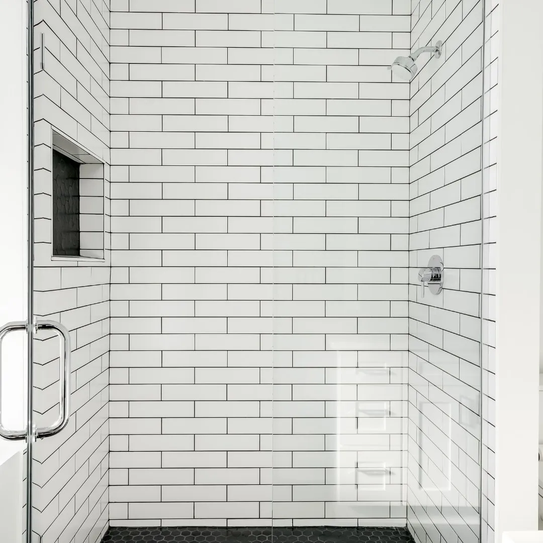 White subway tile shower with a glass door