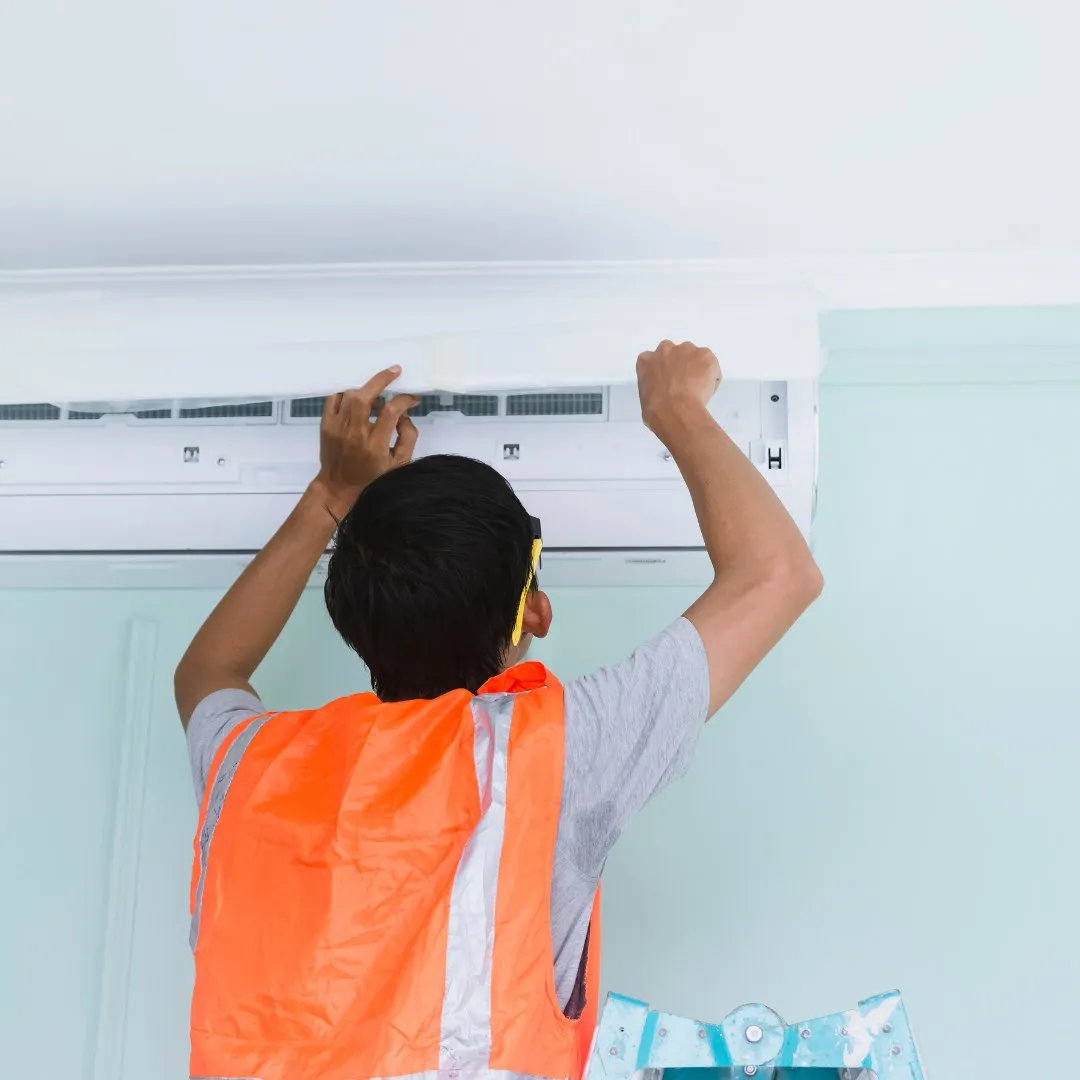Person working on a wall-mounted air conditioner