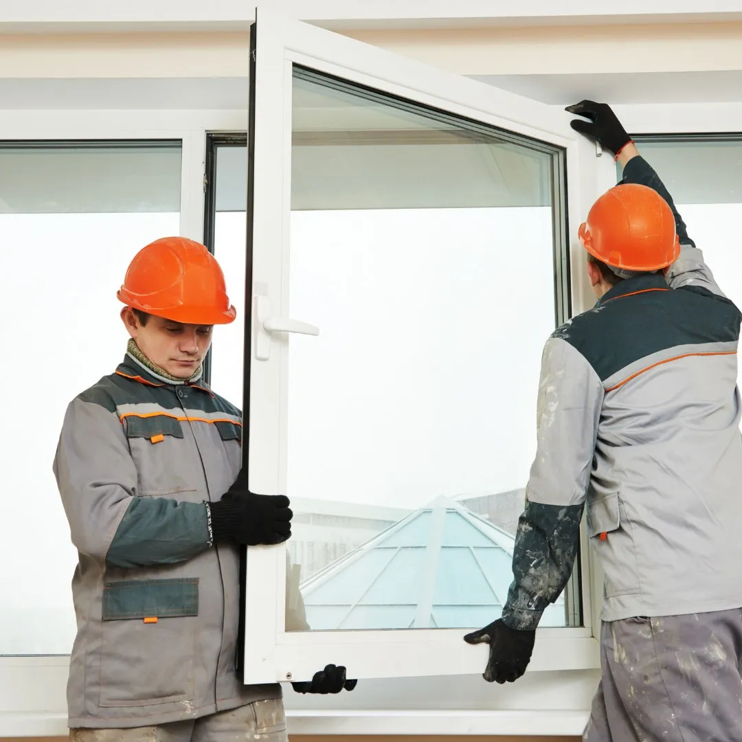 Two workers fitting a window frame